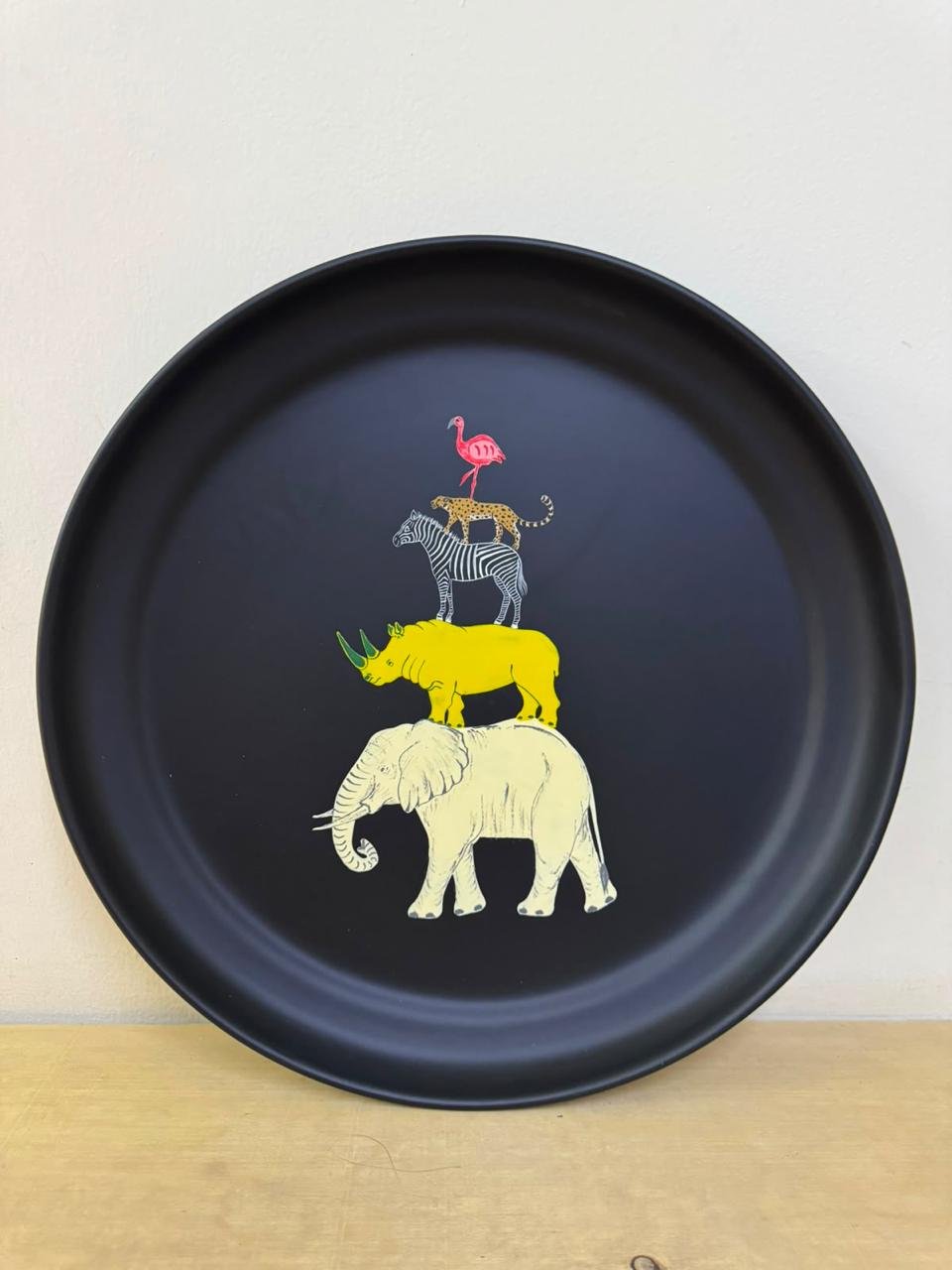 Hand-painted black round tray stacked with a flamingo, leopard, zebra, rhino and elephant — Pink Flamingo's signature design.